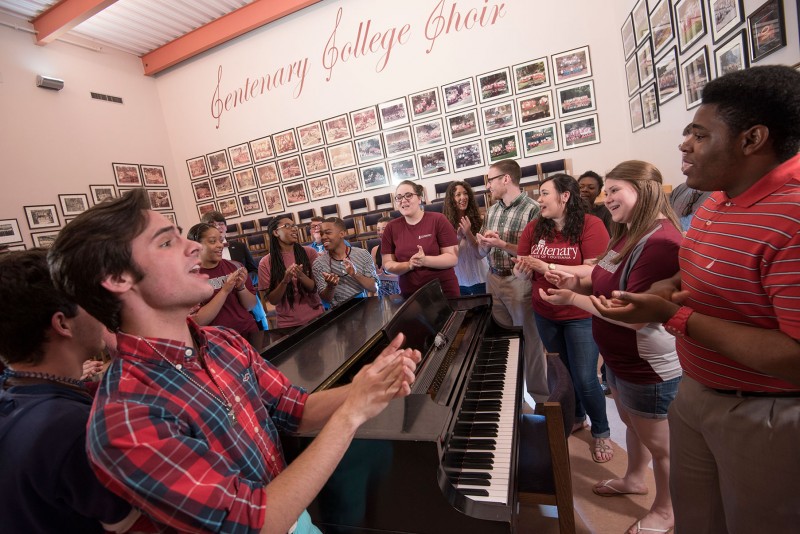 choir students sing around piano