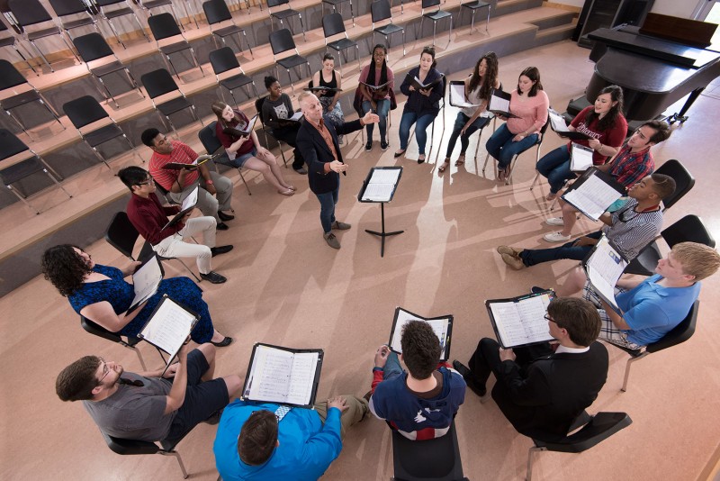 Choir students rehearse in a circle